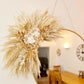 Decorative wall hanging handmade using dried pampas grass and flowers demonstrated here on a mirror