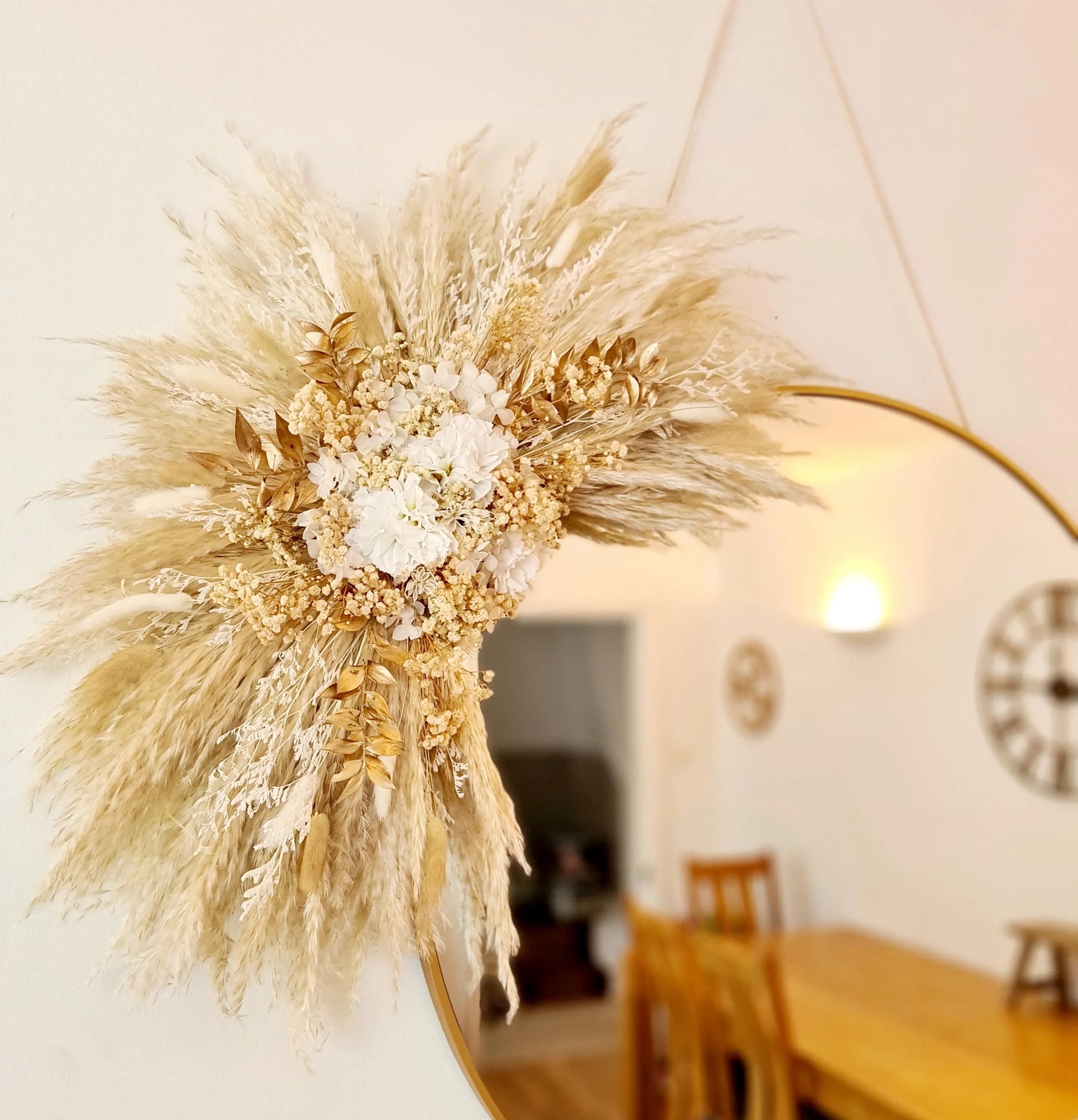 Decorative wall hanging handmade using dried pampas grass and flowers demonstrated here on a mirror